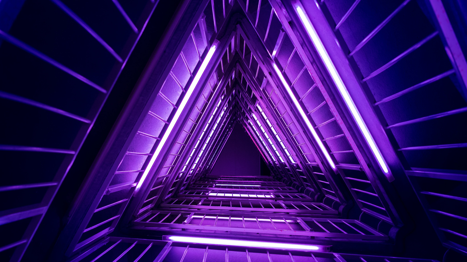 Neon purple lights illuminate a complex structure
